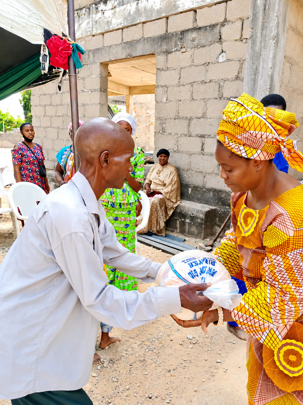 A Funke Adeyemo Foundation volunteer handing out food parcels to a community member.